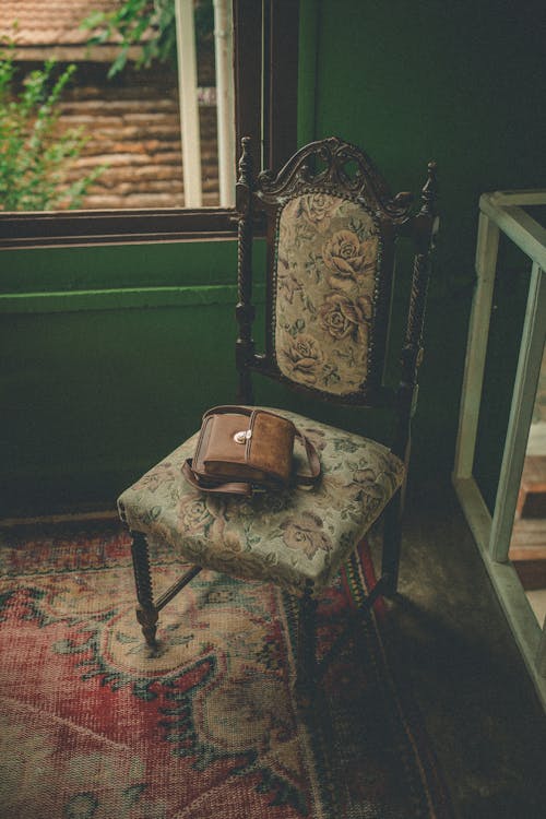 Retro chair with bag on carpet in room