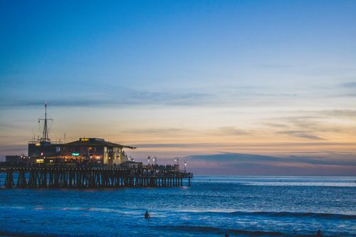 Free Serene twilight scene of Santa Monica Pier with ocean reflection at dusk. Stock Photo
