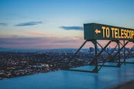 黄昏时分的城市全景中，望远镜标志格外显眼