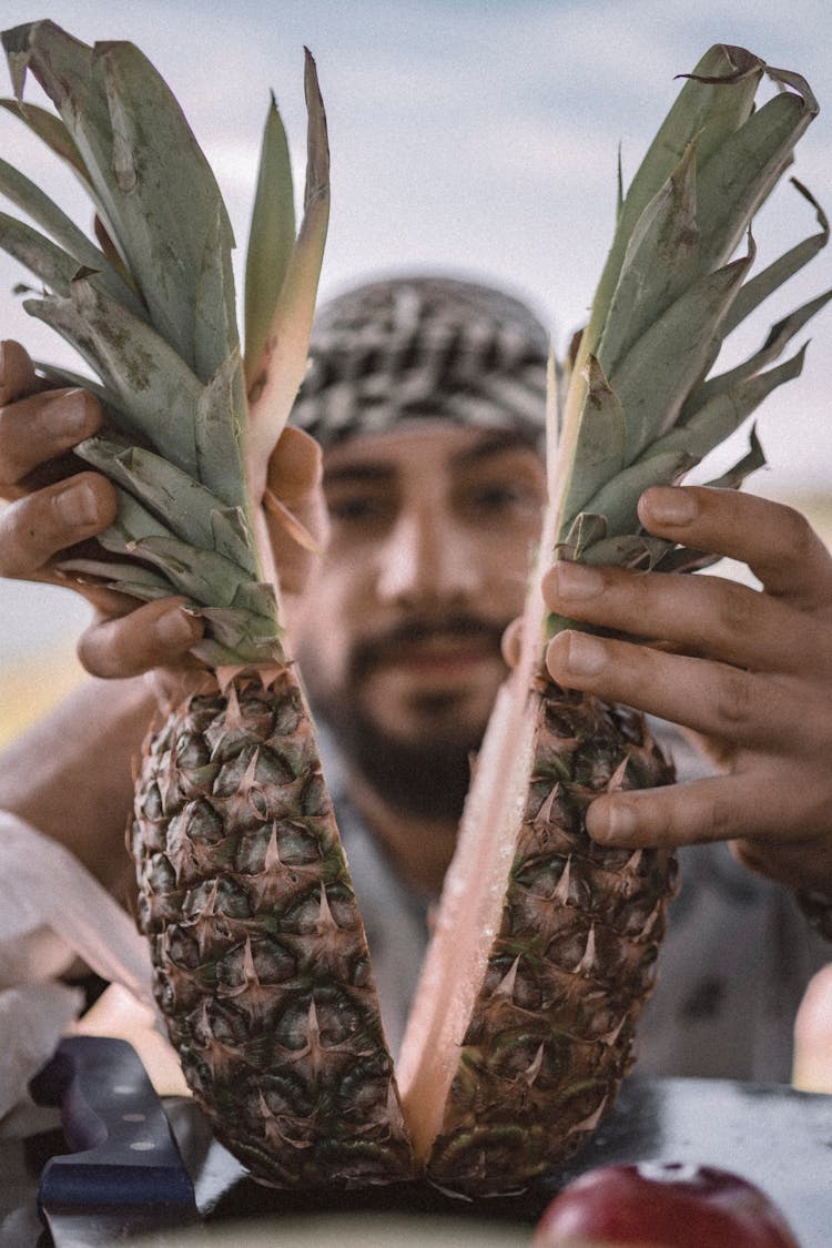 A Man Holding A Pineapple Fruit