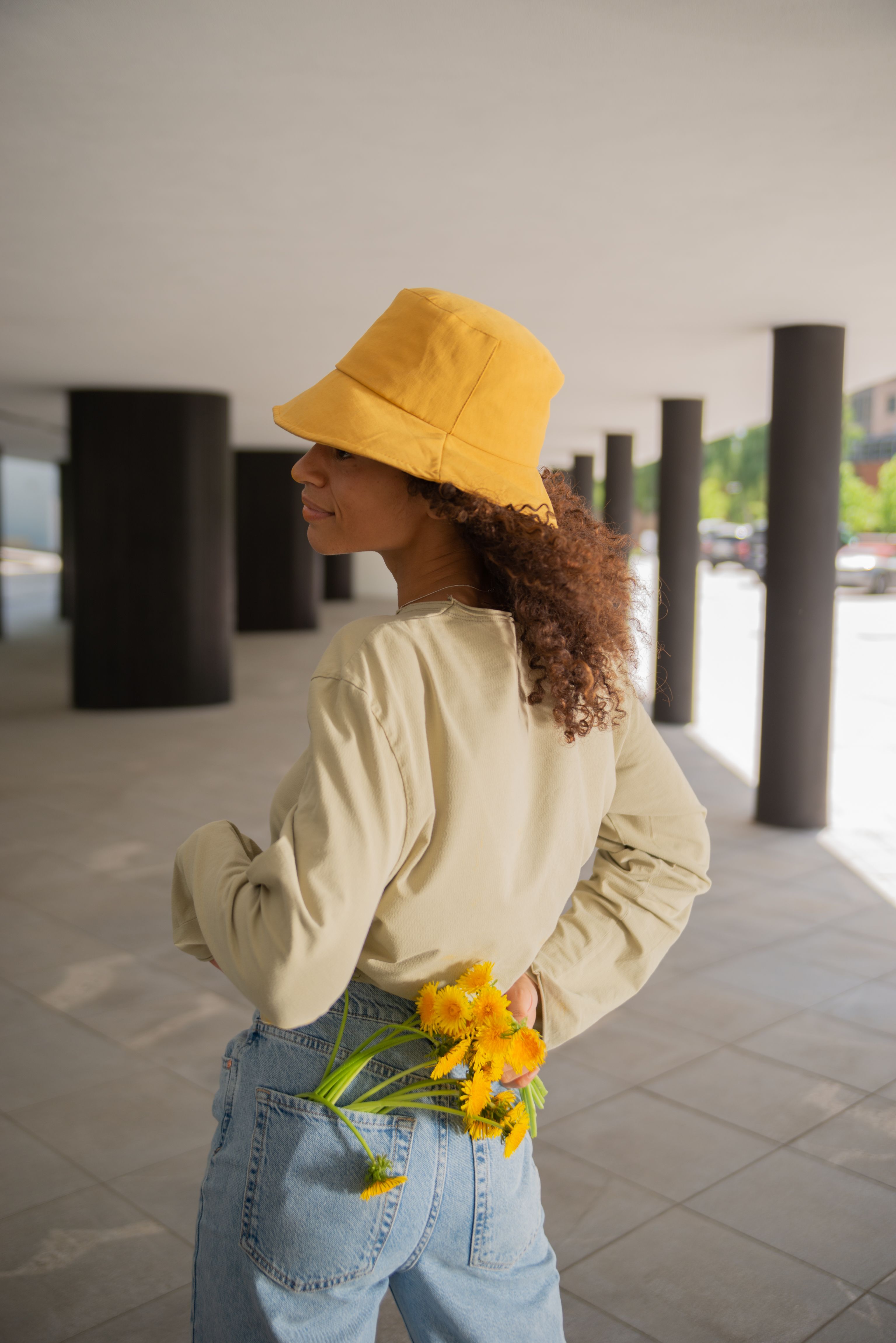 Young Woman Wearing a Yellow Bucket Hat Holding a Bunch of Yellow ...