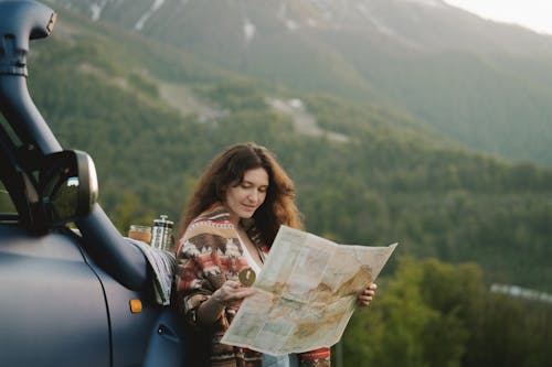 Free A Woman Holding a Map and a Compass Stock Photo