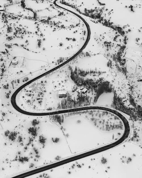 Drone view of curvy road through winter terrain