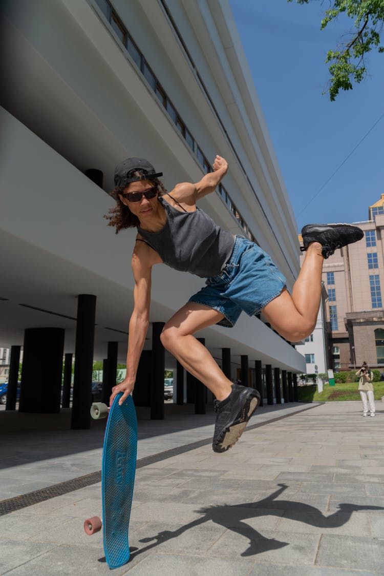 A Woman Holding To A Skateboard Jumping On The Air