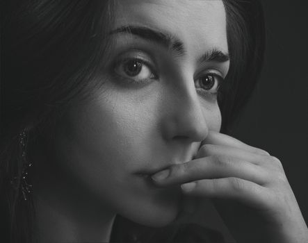 Close-up black-and-white portrait of a woman with thoughtful expression.