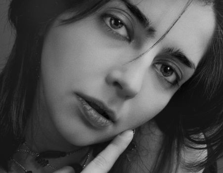 Close-up black and white portrait highlighting female features and emotion.