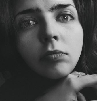 Close-up black and white portrait of a woman with expressive eyes.