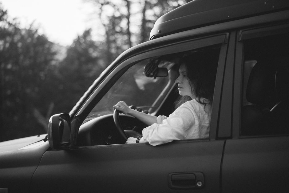 driver-guide talking with travelers, 4x4 vehicle roadside, soft afternoon light