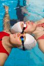 People Floating in the Pool Together with Goggles and Swimming Cap