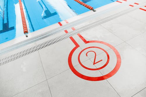 Free Close-up of the number two marking beside an outdoor swimming pool lane. Stock Photo