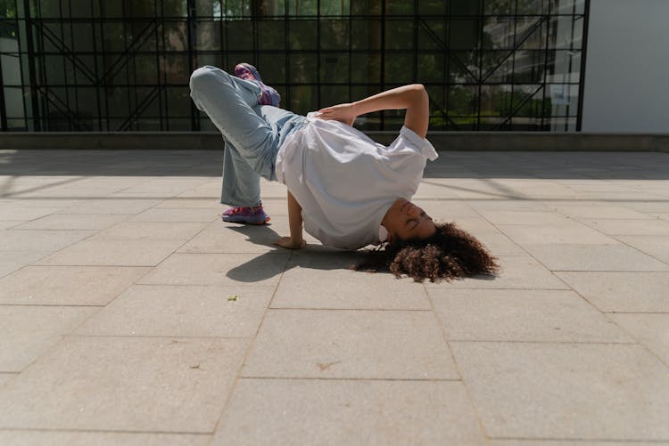 A Woman Breakdancing On Concrete Floor