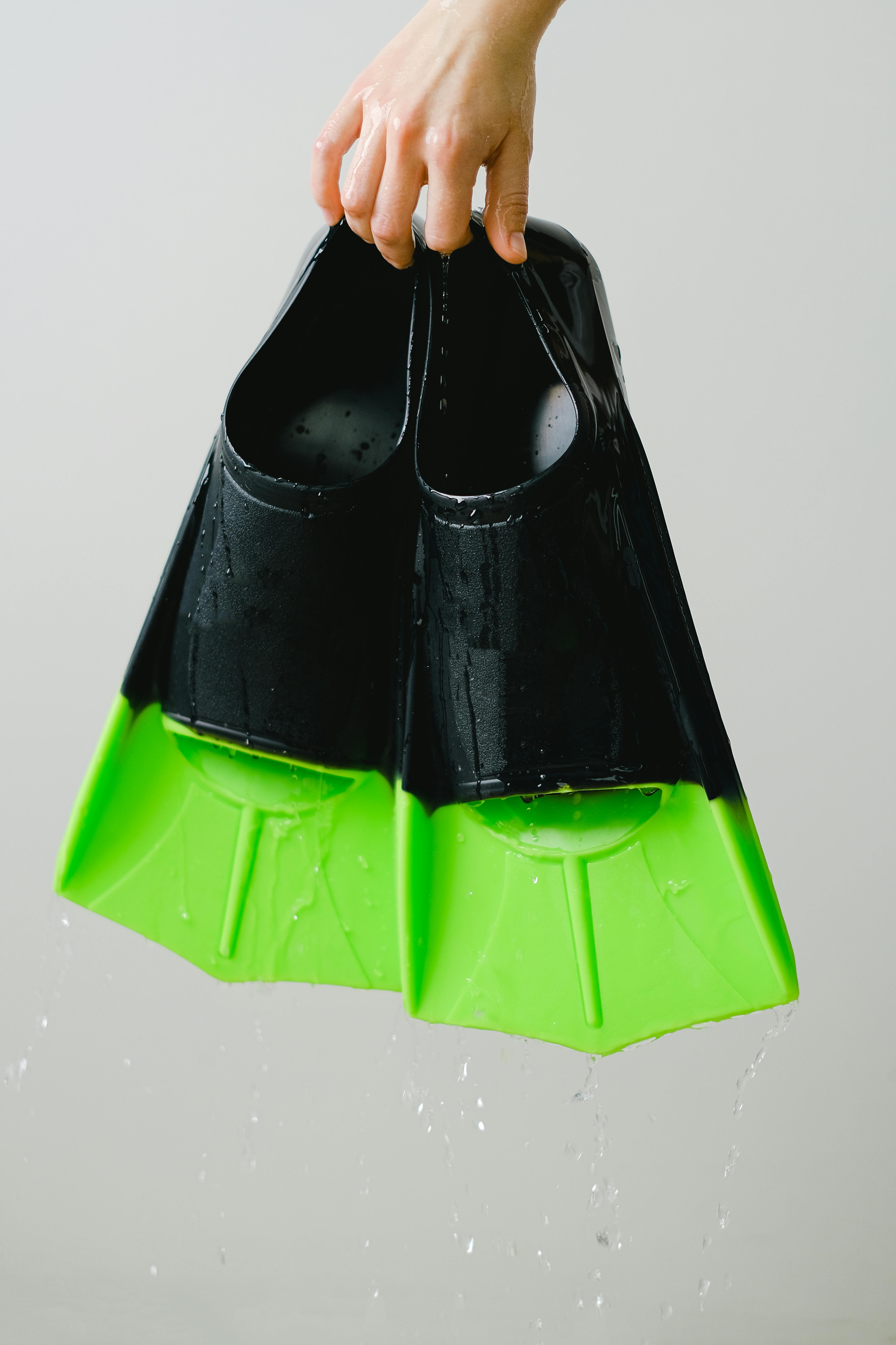 person holding black and green flippers