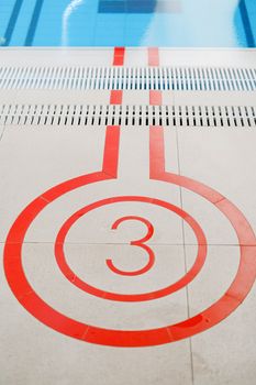 Close-up view of number 3 marking near an indoor swimming pool, emphasizing sport lanes.
