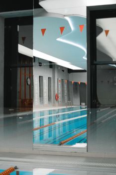 Sleek indoor swimming pool with vibrant reflections and modern design elements.
