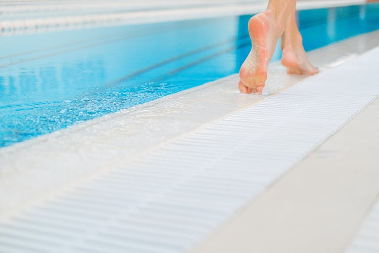 A Person Walking By The Swimming Pool