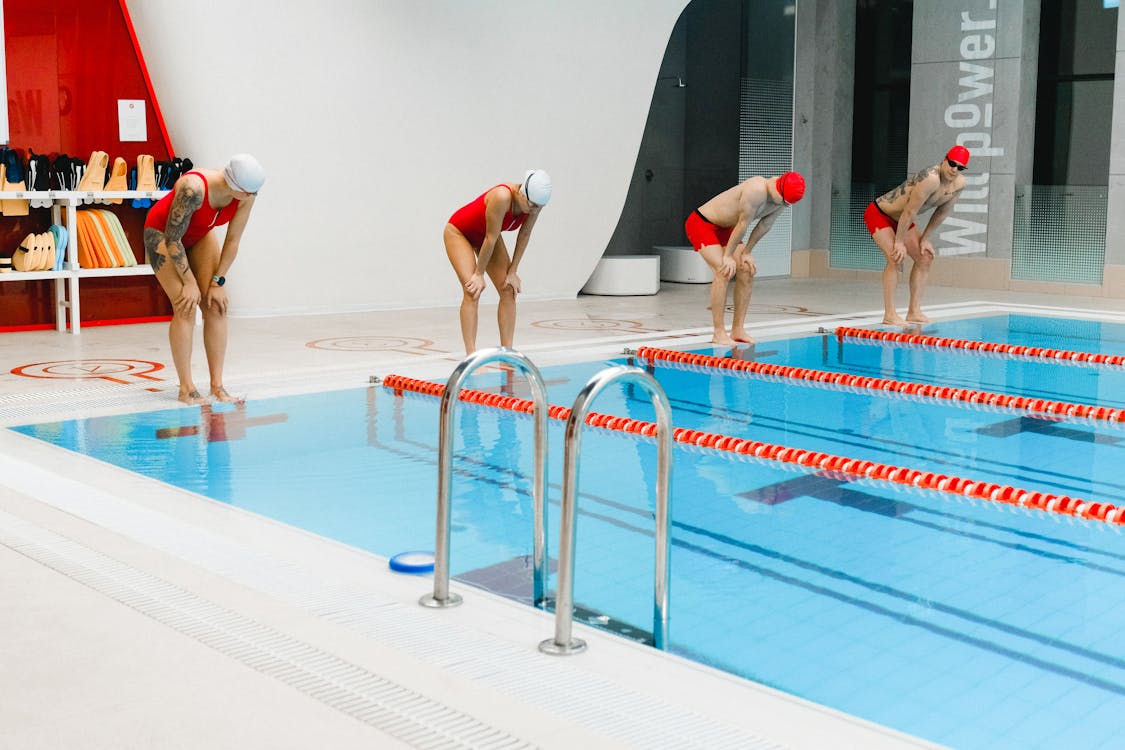 People Standing on the Edge of a Swimming Pool