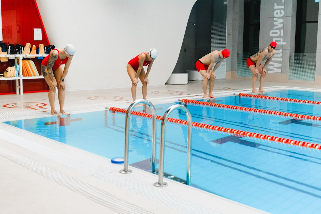 Swimmers standing at the edge of a swimming pool