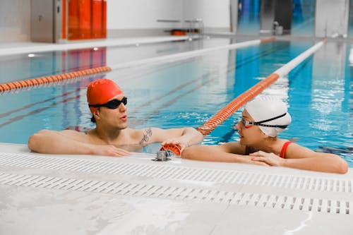 A Man and a Woman Talking while in a Pool