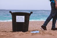 Black Plastic Bucket on Brown Sand Near Body of Water