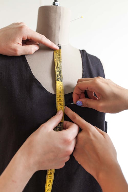 A Person Putting a Pin on a Black Dress 