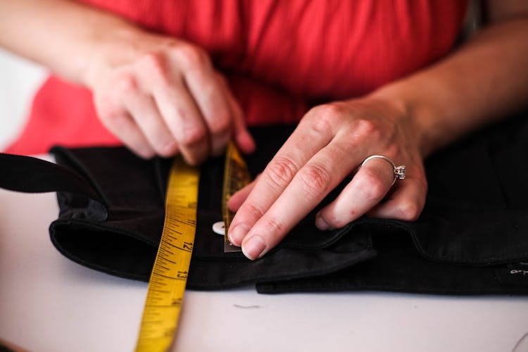 A Woman Using Tape Measure In Dress Making