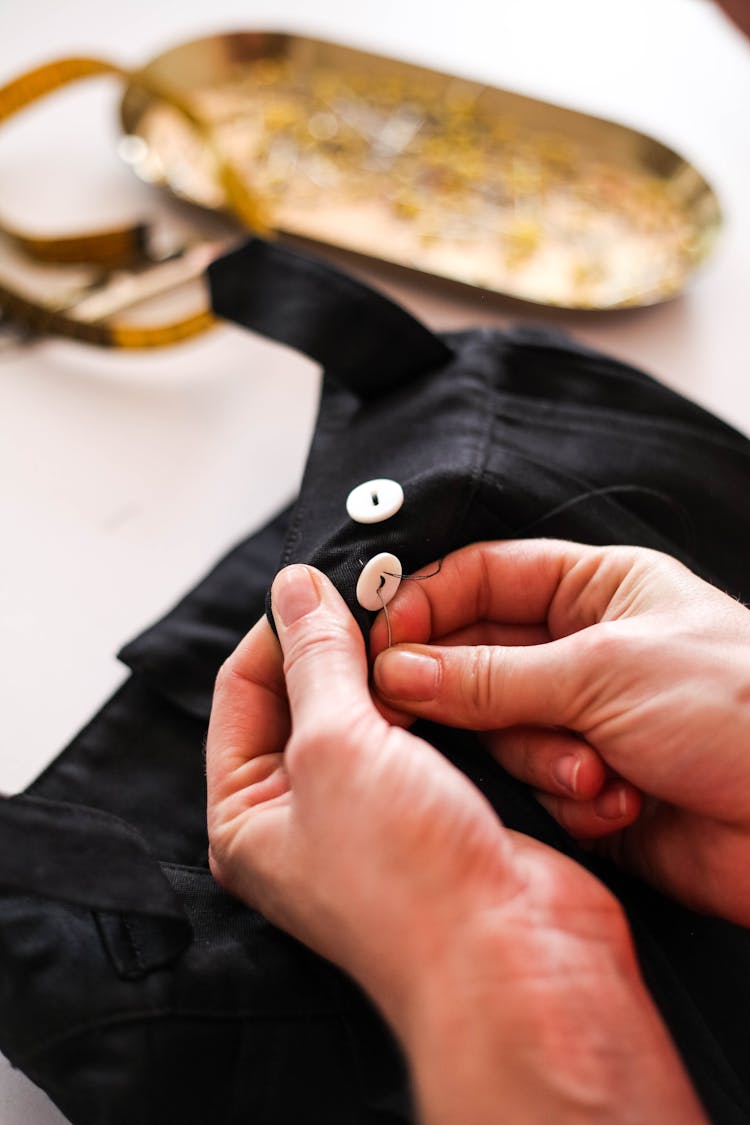 A Sewer Sewing Buttons On A Dress