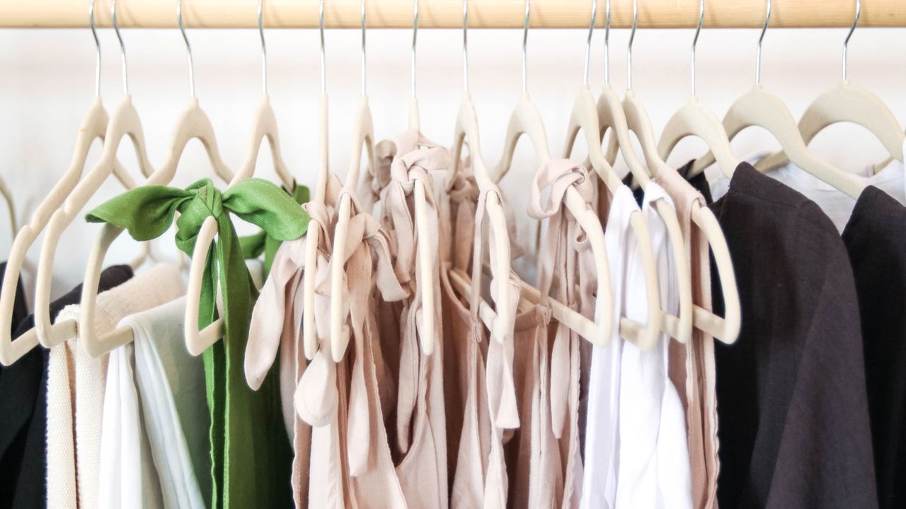 Coordinated capsule wardrobe clothing Coordinated clothing on wooden hangers for easy capsule wardrobe outfit combinations