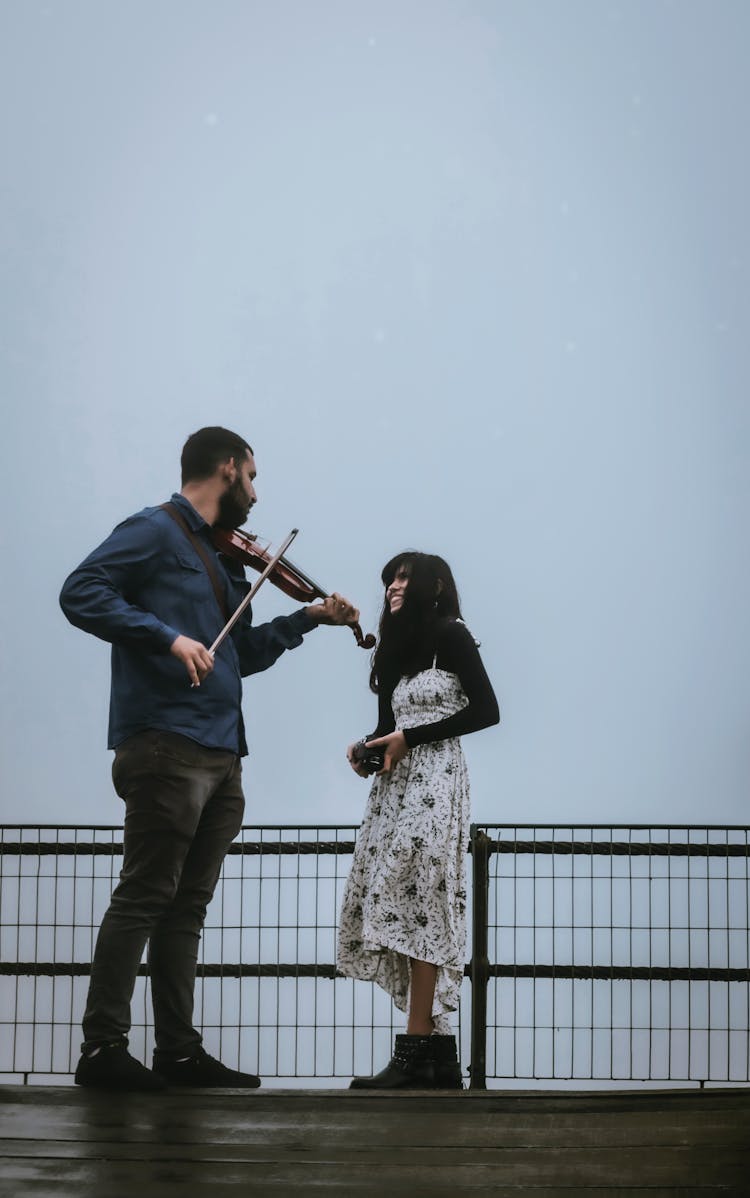 A Man Playing Violin For His Woman