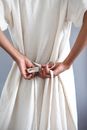 A Woman Tying Her White Dress at the Back
