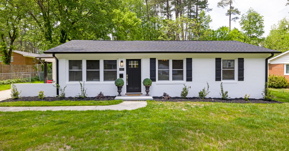 Front view of a charming suburban ranch house with modern landscaping and fresh paint, capturing the essence of cozy living.