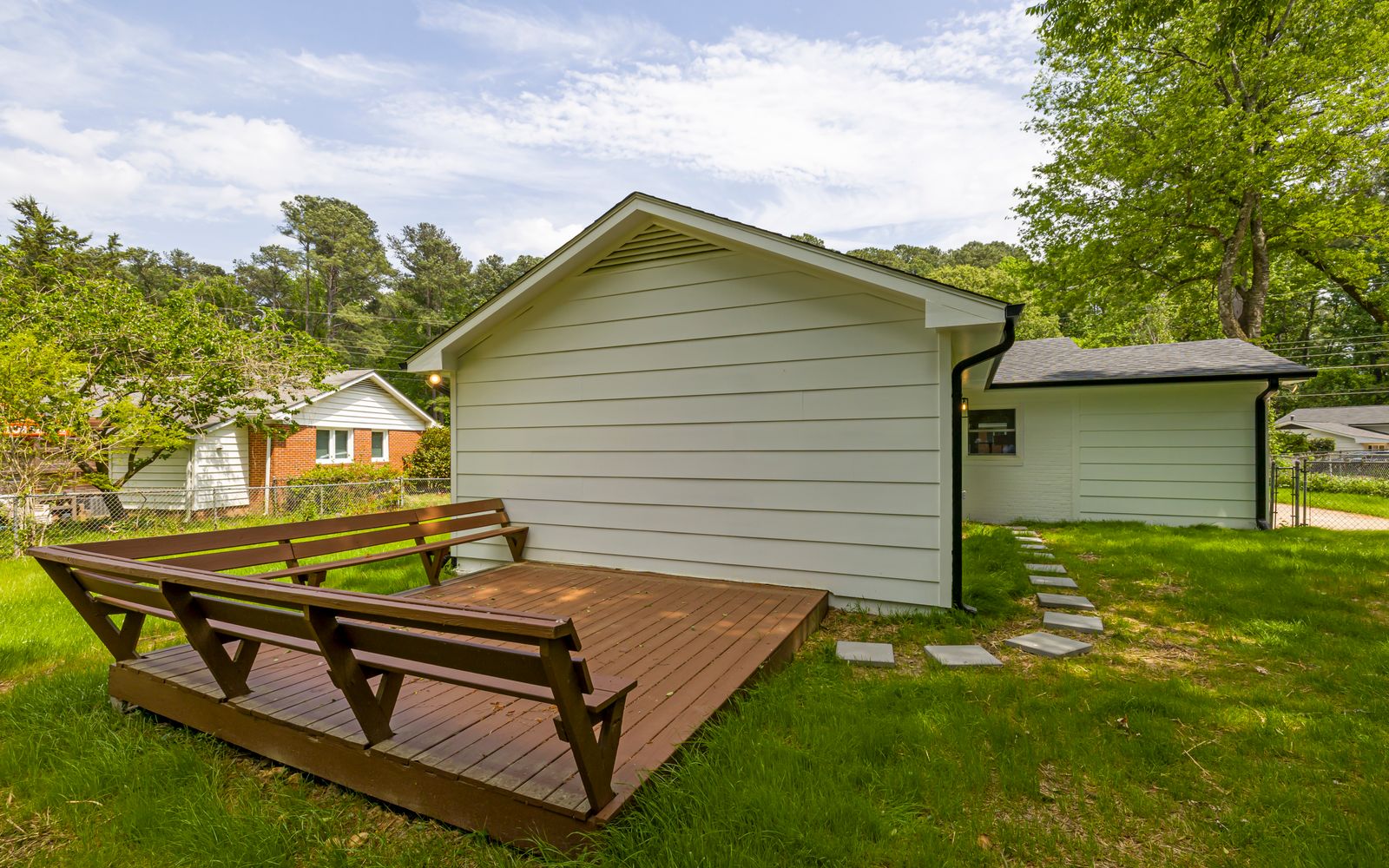 A timber patio in the back garden of a house