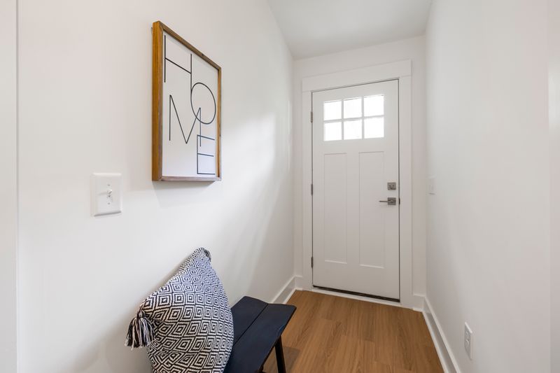 Bright minimalist entryway hallway with a slim bench and simple decor