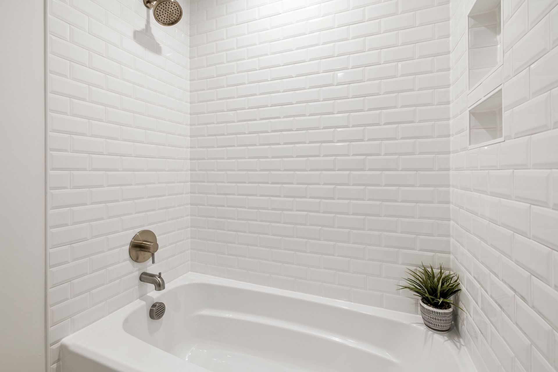 Bright minimalist bathroom with white subway tiles and a bathtub for a clean, contemporary feel.