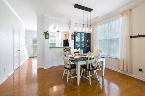 Free A White Wooden Dining Table Near the Window Stock Photo