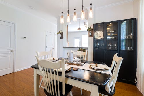 A Dining Room with Wooden Table and Chairs and Pendant Lamps