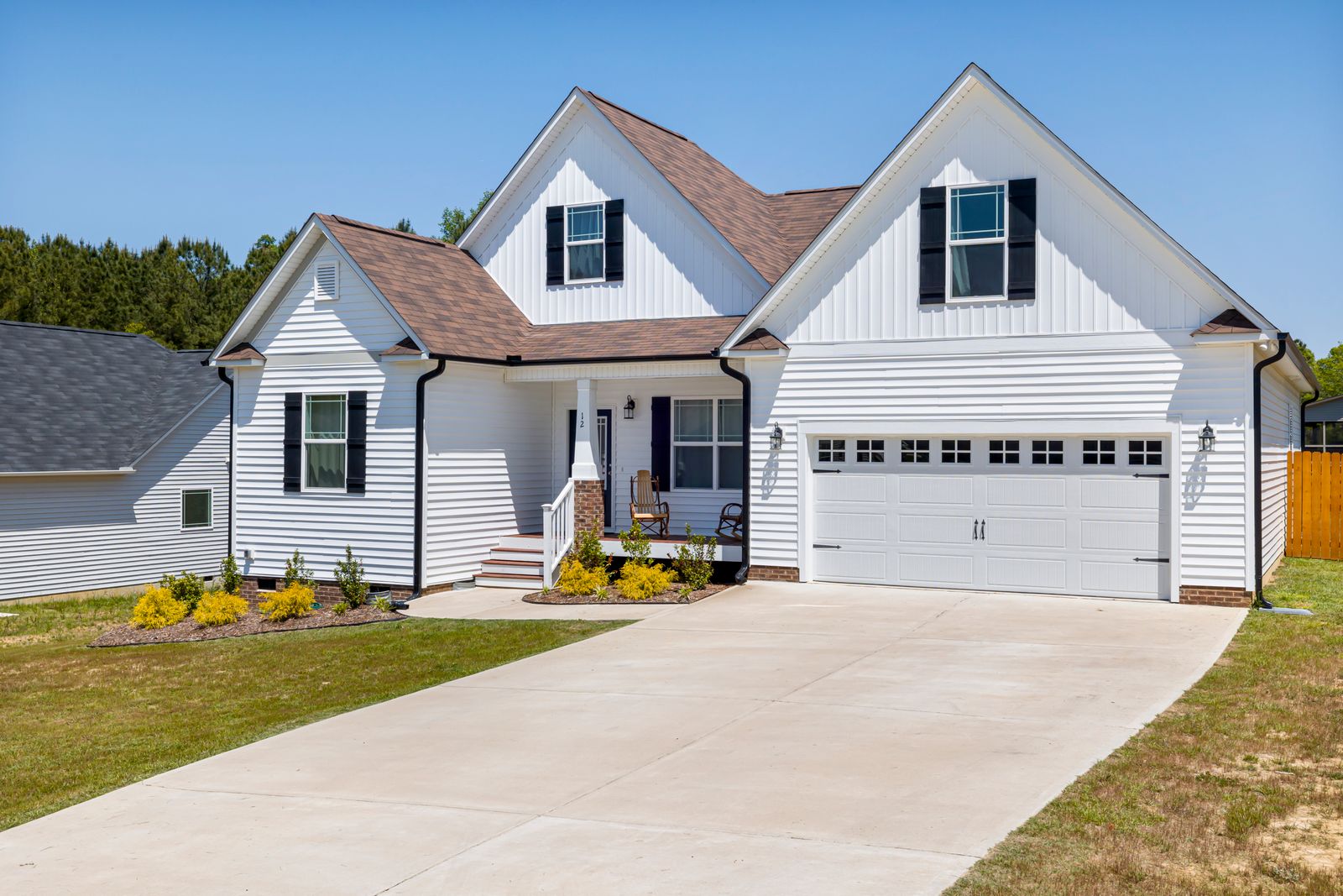 New driveway at white home with black shutters