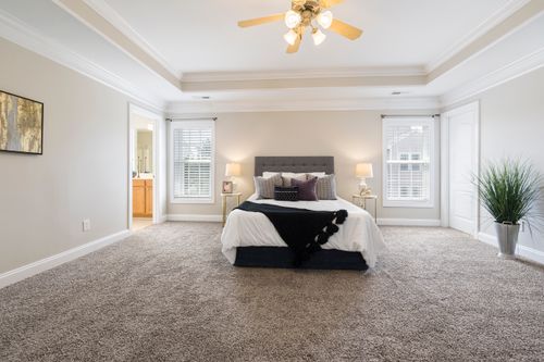 Free Bright and spacious bedroom with modern decor featuring a plush bed and soft lighting. Stock Photo