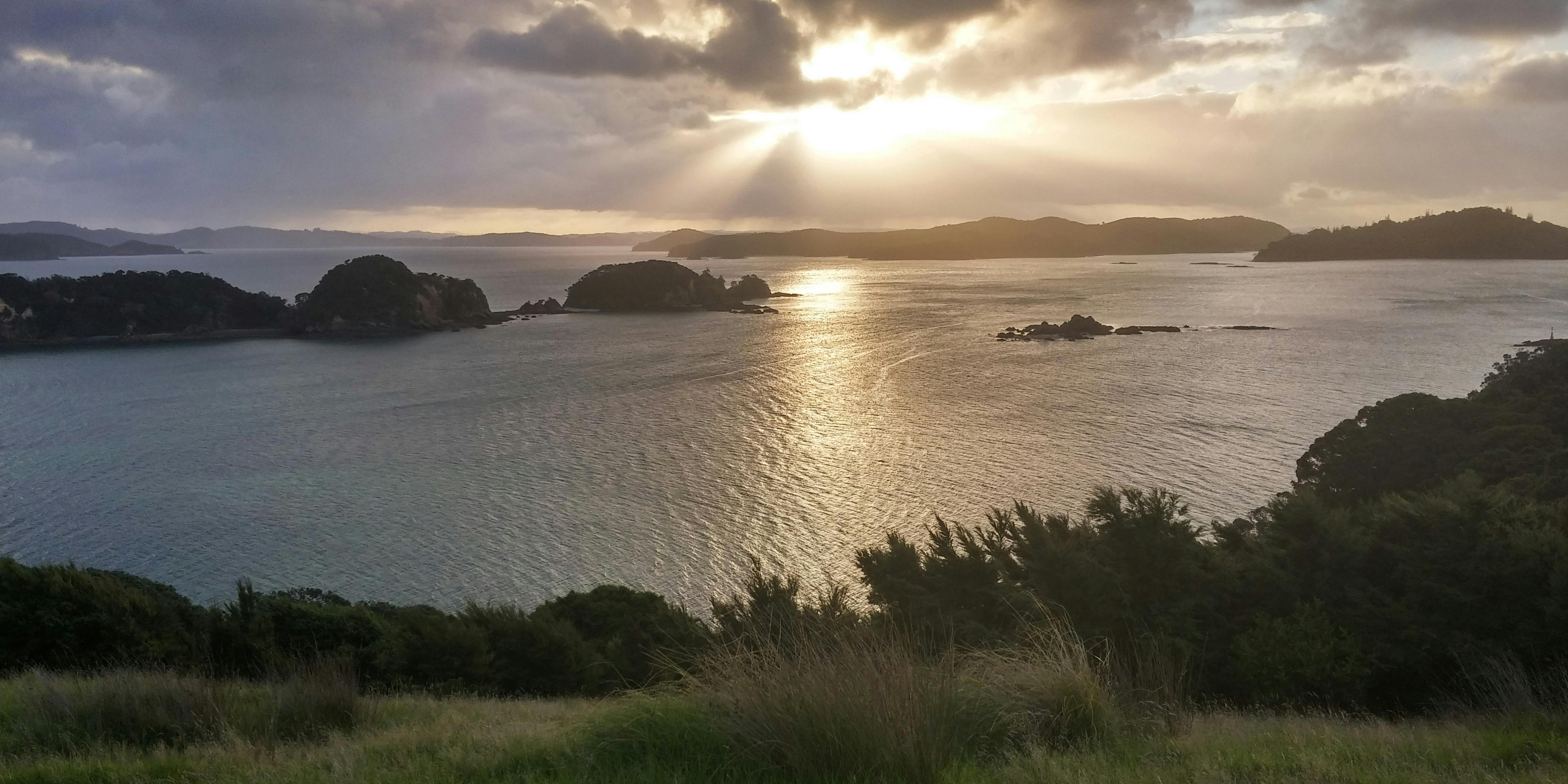 海湾沿岸的日落令人惊叹，那里有岛屿和波光粼粼的海水