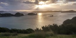 海湾沿岸的日落令人惊叹，那里有岛屿和波光粼粼的海水