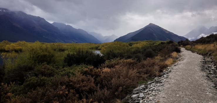在新西兰多云天空下，宁静的山路景色令人惊叹
