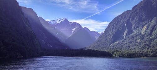 Body Of Water Near Mountain Under Clear Sky