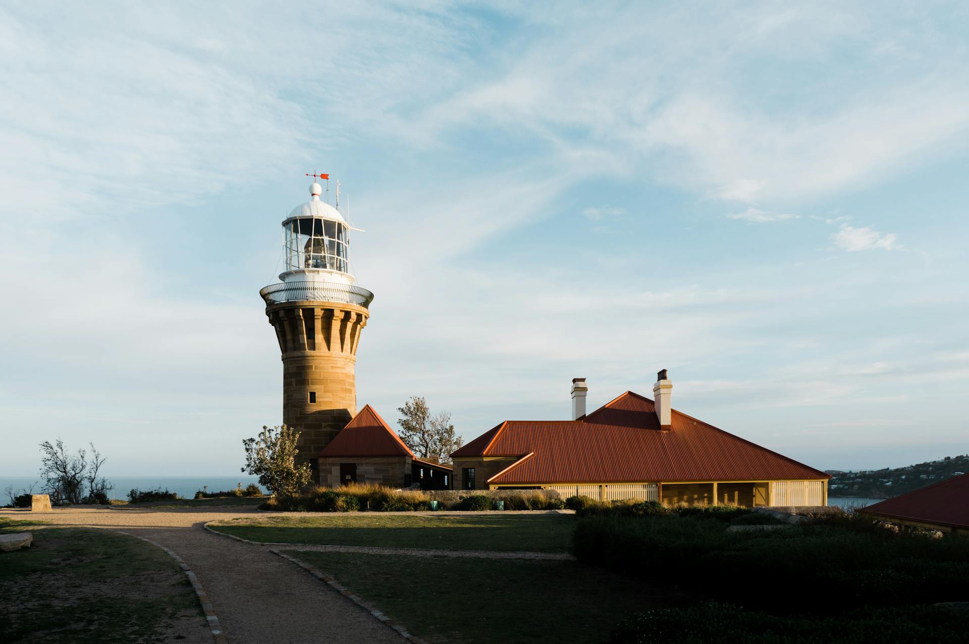 Scenic view of Barrenjoey Lighthouse and buildings in Sydney, showcasing iconic coastal architecture.