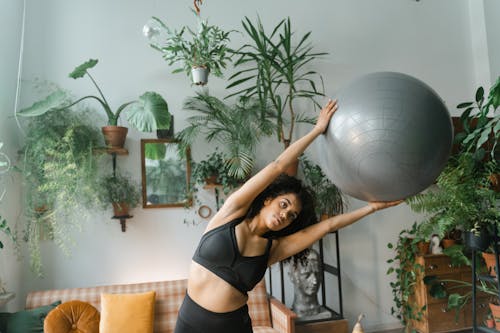 Free Woman in Black Activewear Holding a Yoga Ball Stock Photo