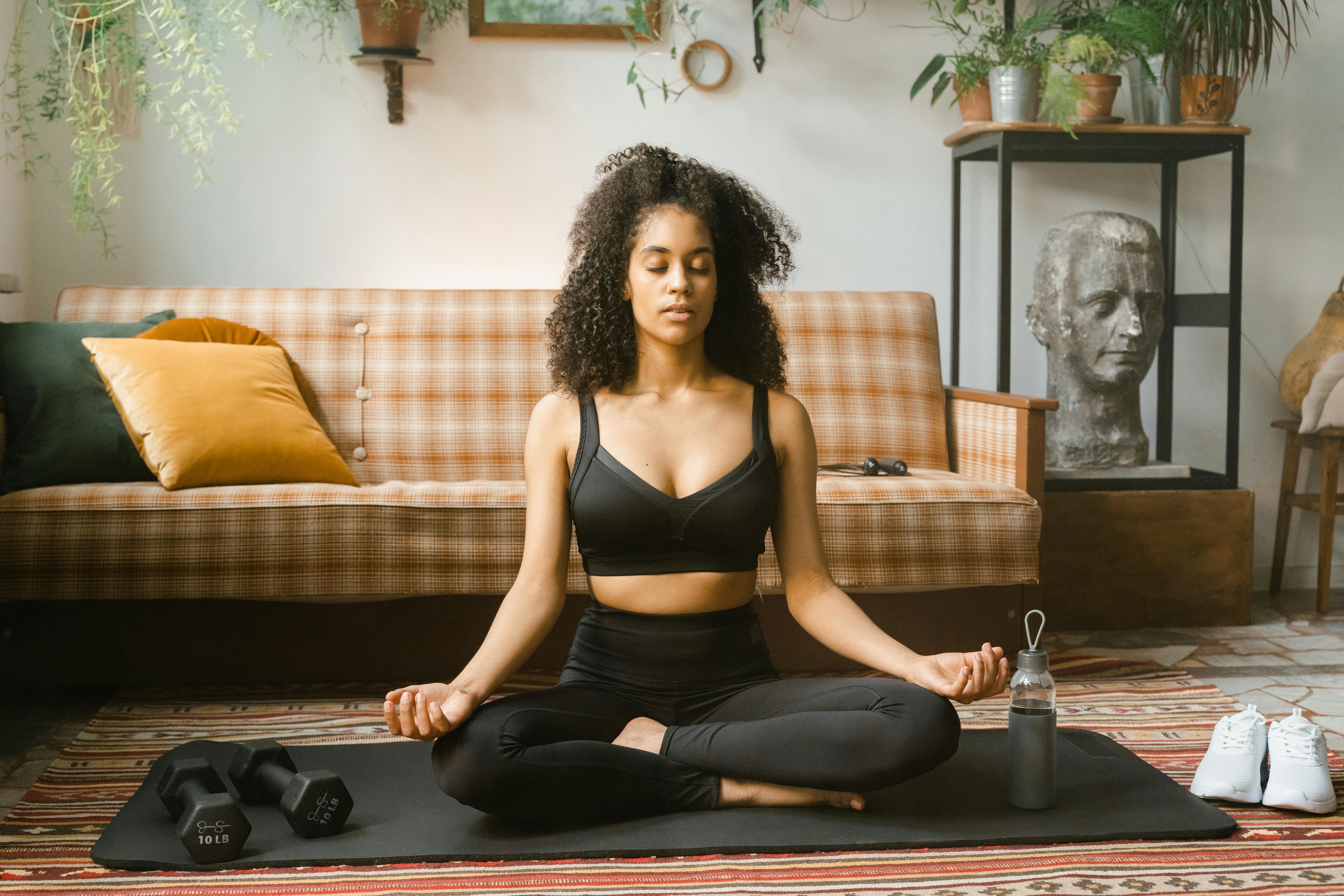 Free Woman in Black Activewear Meditating Indoors Stock Photo