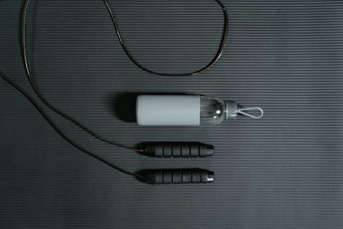 Photo of Jump Rope and Water Bottle on Yoga Mat