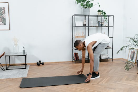 Black man practicing yoga indoors with mat, promoting healthy lifestyle and body care.