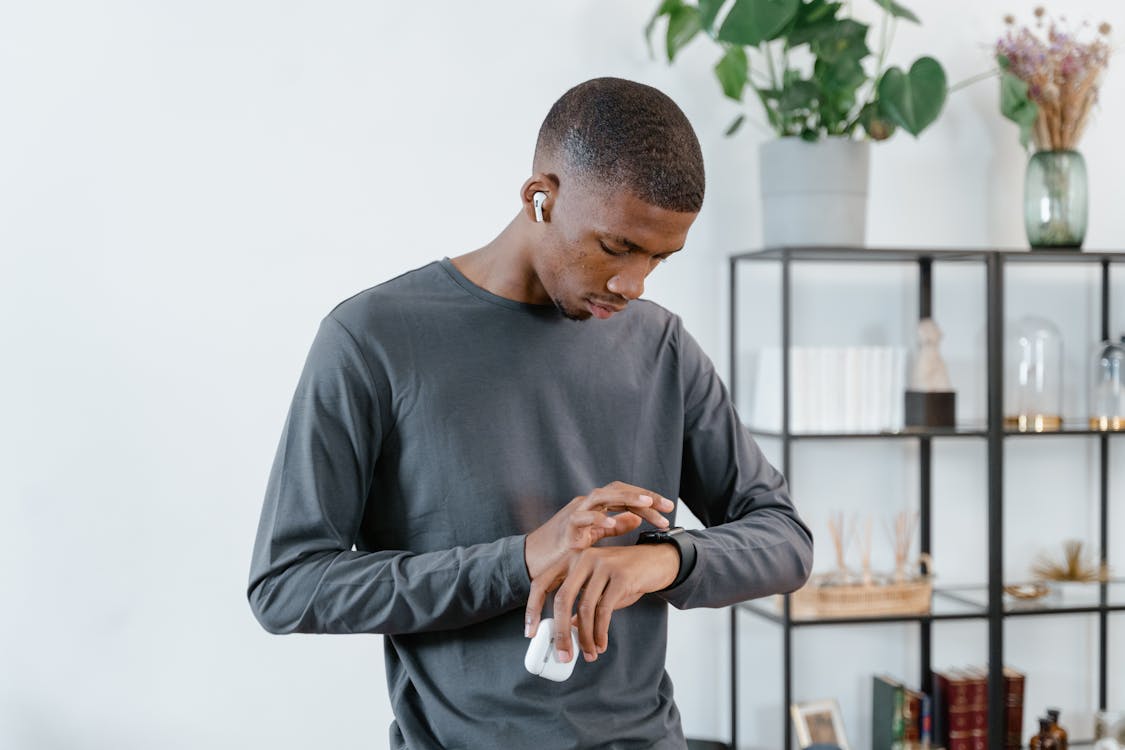 Free Man in Gray Sweater Using His Smartwatch Stock Photo