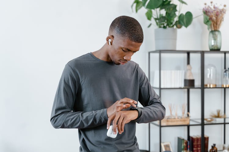 Man In Gray Sweater Using His Smartwatch