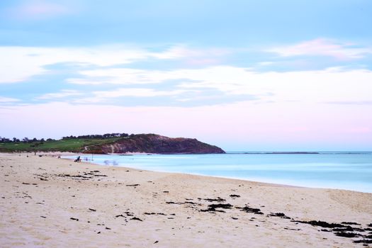 Serene Australian coastline captured at twilight with calm seas and sandy shore.
