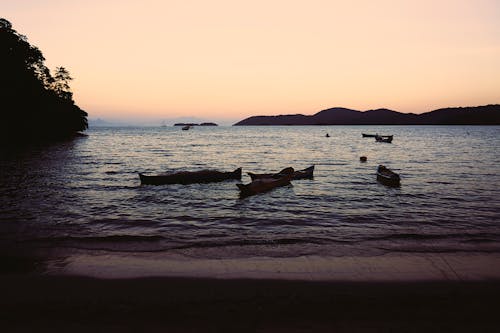 Бесплатное стоковое фото с закат, лодки, море